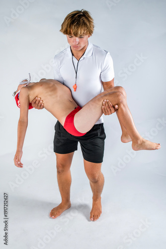 Foto Water polo coach carrying young swimmer after incident in pool