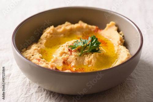 Healthy vegan snack, chickpea hummus dip topped with paprika and fresh parsley