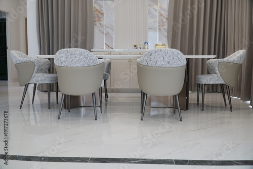 White and black chair is sitting in front of a white table