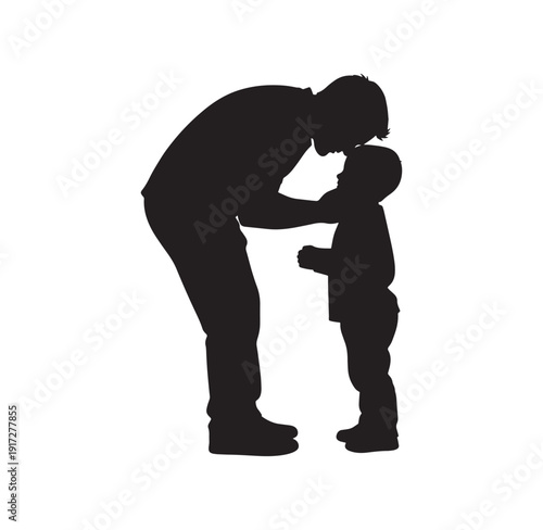 Silhouette of a man kissing a little boy on the forehead in a tender moment