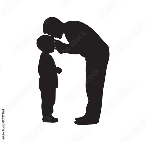 silhouette of a man kissing a little boy on the forehead standing side by side