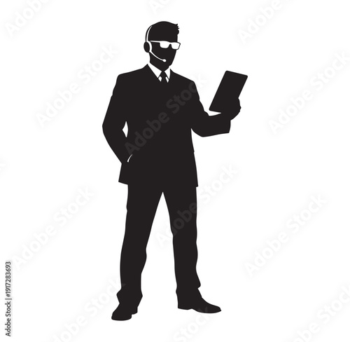 Silhouette of a businessman in a suit holding a tablet and wearing a headset  standing confidently