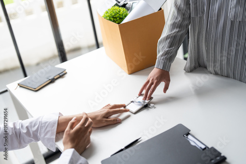 фотографія Business woman sending resignation letter to boss and Holding Stuff Resign Depress or carrying cardboard box by desk in office
