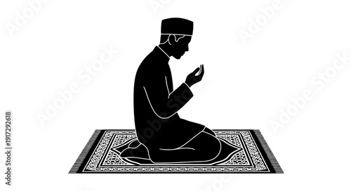 A man is sitting on a prayer mat and praying