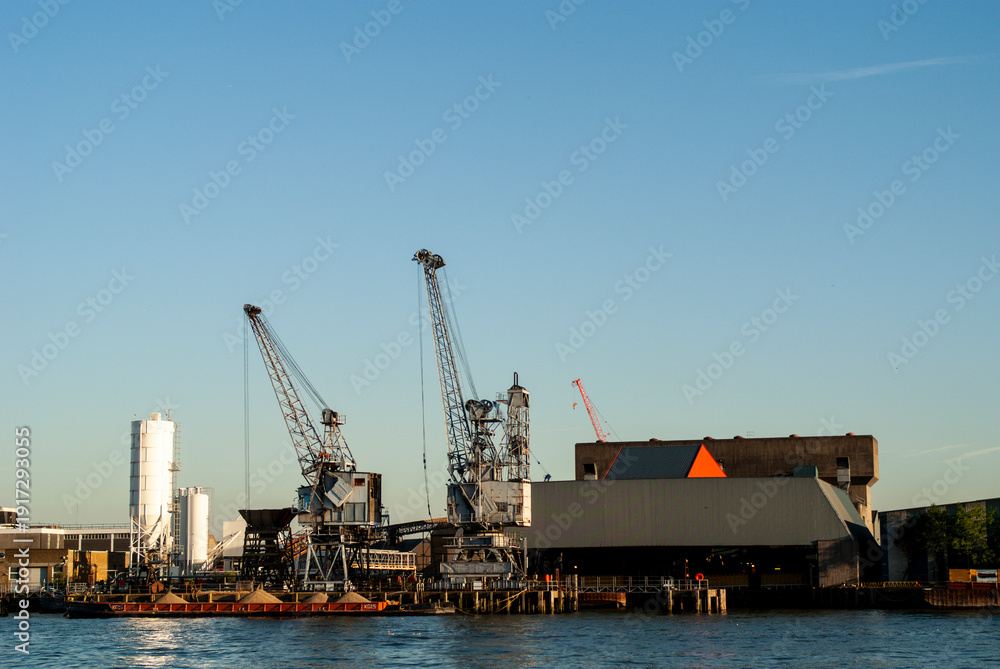 Obraz premium Industrial port harbor with cranes and cargo barge