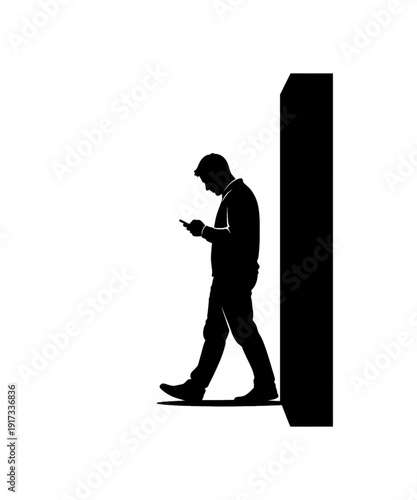 Silhouette businessman walking while using smartphone near tall column in modern office