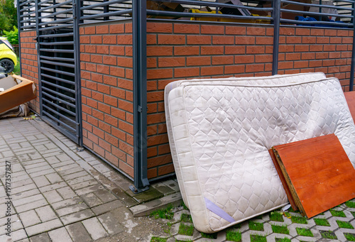 Принти на полотні Bulky waste and old mattress abandoned near residential garbage shelter, urban waste management issue, ecology and cleanliness in public space, illegal dumping, autumn day outside