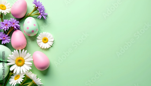 Colorful Easter eggs with spring daisies and lilacs on a mint background