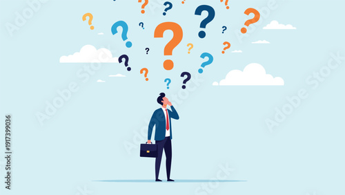 Pensive businessman in a suit stands looking up at a cloud of colorful question marks while searching for answers or making a big decision.