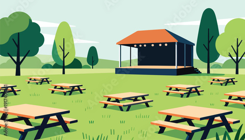 Outdoor stage with picnic tables arranged on a grassy field