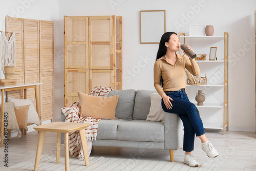 Young Asian woman drinking ...