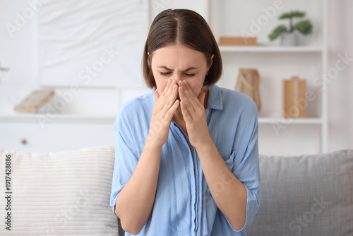 Allergic young woman sneezi...
