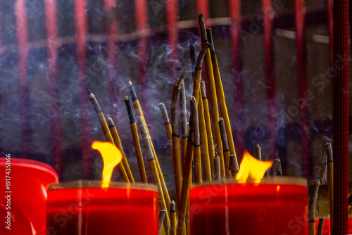 traditional incense sticks burning in a temple setting.  These sticks are commonly used in Southeast Asia for religious worship, meditation, and paying respect to the Buddha.