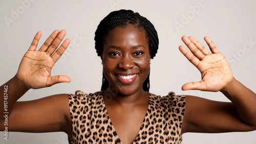 Wallpaper Mural A beautiful Black woman with a radiant smile and open palms poses confidently in a studio. Torontodigital.ca