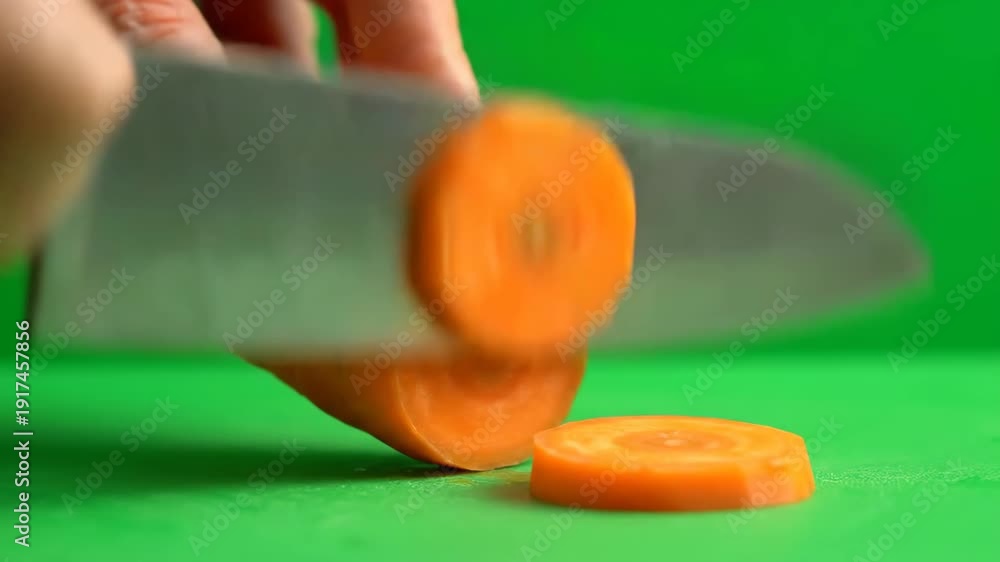 custom made wallpaper toronto digitalA chef's knife expertly cuts a vibrant orange carrot into uniform round slices on a bright green surface.