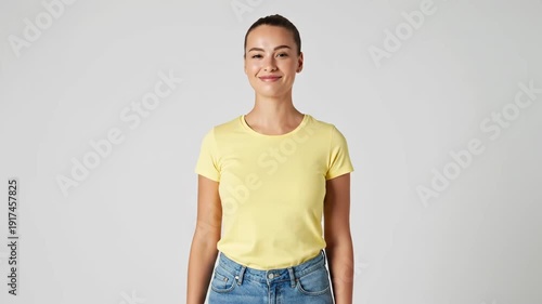 Wallpaper Mural A cheerful young woman in a yellow t-shirt flexes her biceps and claps, radiating confidence and joy. Torontodigital.ca