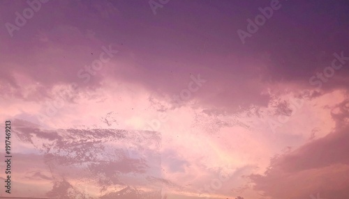 Dramatic pink and purple sky at dusk with hazy cloud cover