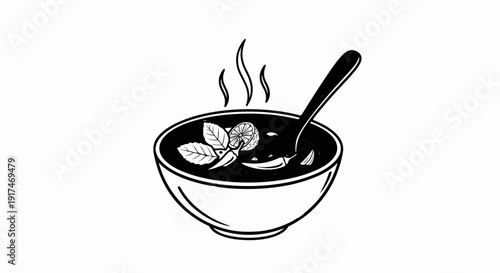 A steaming bowl of dark soup, garnished with mint, lime, and chili peppers