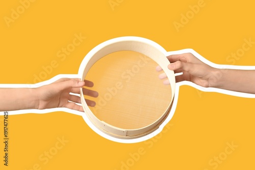 Bilde på lerret Female hands with sieve on yellow background