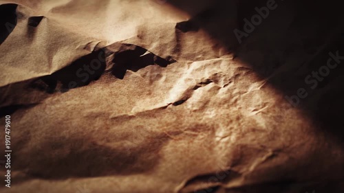 Distressed brown paper creating a vintage texture, featuring dramatic shadows and highlights across its crumpled surface, useful for backgrounds and aged effects
