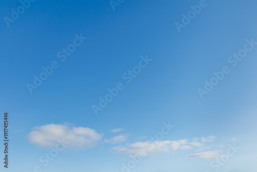 Blue sky with small white clouds near horizon