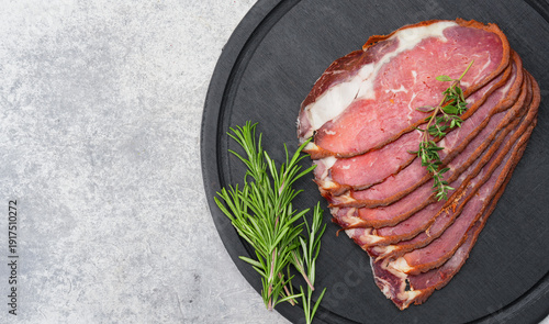 Delicious traditional dried pastrami slices on grey stone  background