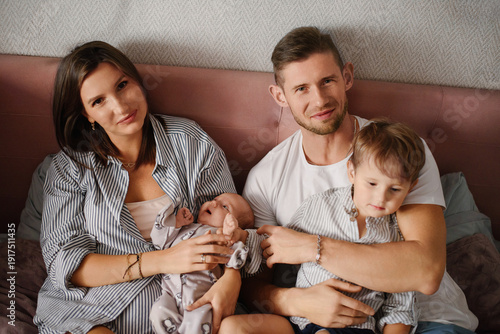Young Family Relaxing With Newborn And Toddler