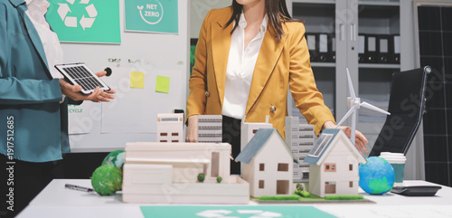 
 Two business people team planning and discussing of sustainable and renewable clean energy product with solar cell and wind turbine generator, CO2 emissions climate change global warming project