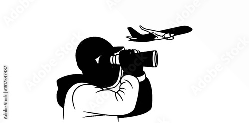 Person wearing a baseball cap and hoodie looks through binoculars at a plane
