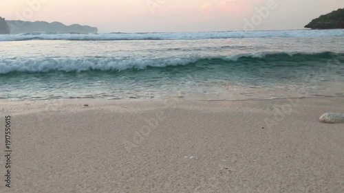 Serene tropical beach landscape with rolling waves and soft evening light.