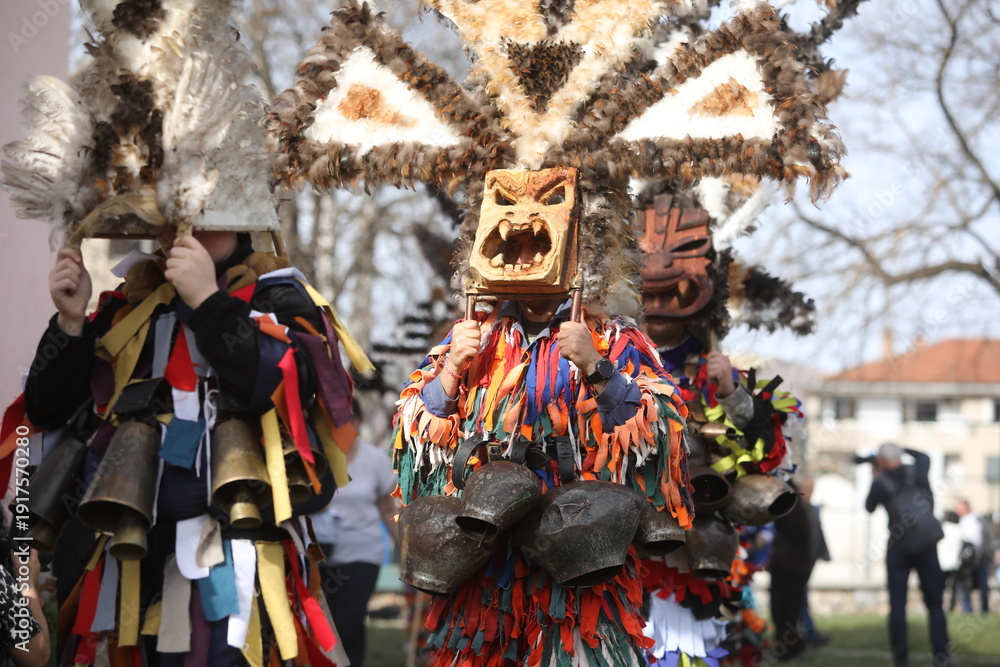 Fototapeta premium Zemen, Bulgaria - March 15, 2025: Masquerade festival Surva in Zemen, Bulgaria. People with mask called Kukeri dance and perform to scare the evil spirits.