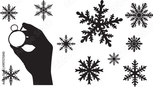 Hand holding Christmas ornament with snowflakes around it