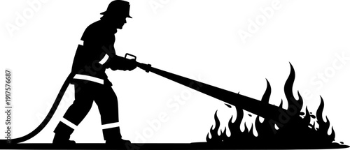Silhouette of a firefighter using a high pressure hose on a fire