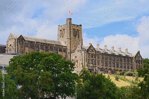 Exterior view of Bangor University in Wales under a clear blue sky, showcasing classic academic architecture and a peaceful campus atmosphere.