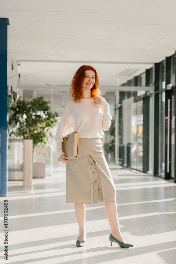 Obraz premium Professional woman walking through modern office corridor