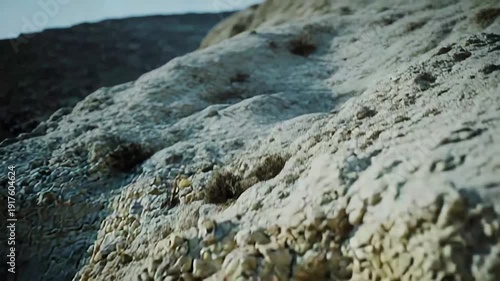 Diverse geological materials creating a layered rock formation, highlighting the natural weathering and erosion of different sedimentary strata on a rugged outdoor slope