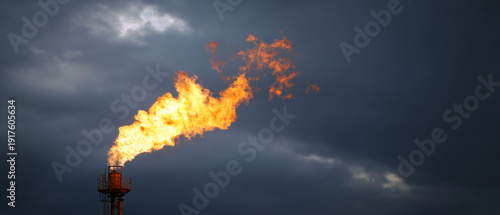 Industrial Gas Flare Burning at Oil Refinery Against Dramatic Cloudy Sky, Fossil Fuel Emission Concept