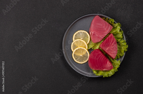 Photography Raw tuna steaks with lemon and lettuce