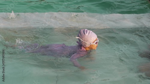 slow motion of preschool child girl playing and swimming with her mother in the pool

