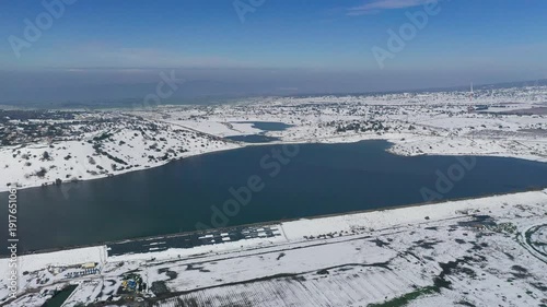 Aerial view of a snowy Bental reservoir in winter in the Golan Heights
