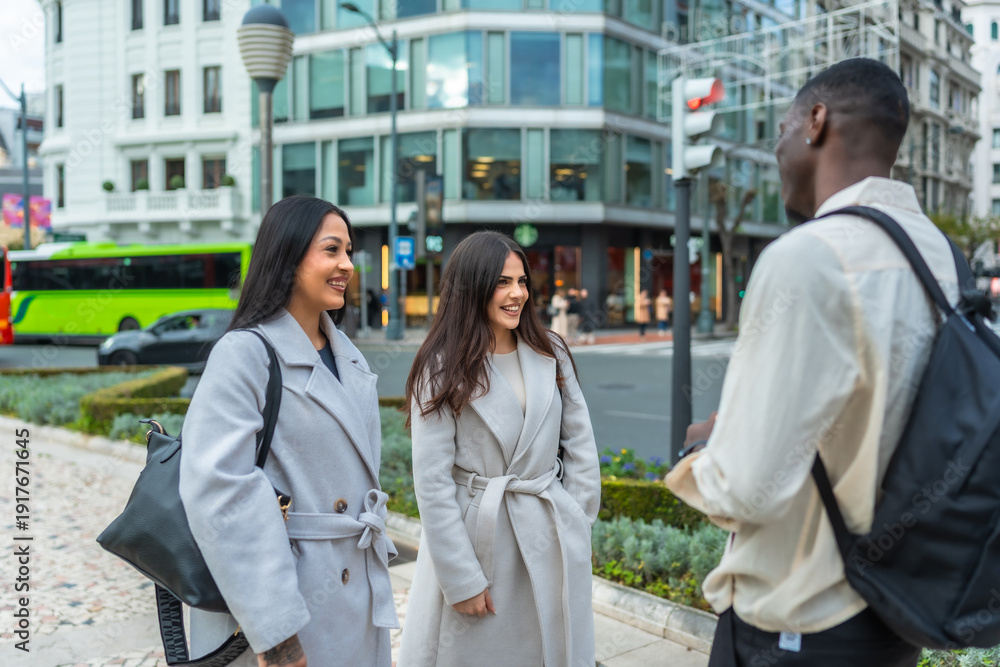 Fototapeta premium Young diverse friends meeting on city street for conversation