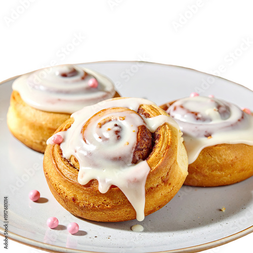 Three frosted cinnamon rolls on a light-colored plate