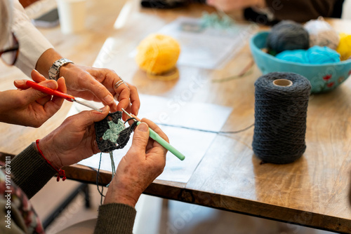 Photography Hands crocheting yarn together in craft workshop