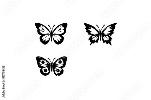 A collection of three white butterfly silhouettes set against a stark black background. The designs vary in wing shape and internal patterns, including circular eye-spots.