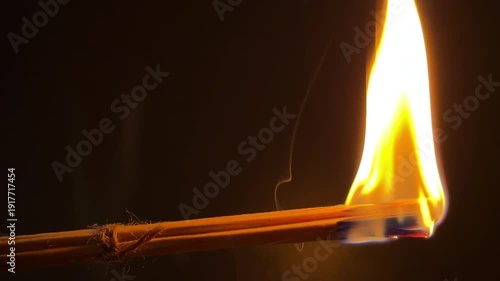 A bundle of wax-coated wooden splinters ignites into a bright, steady flame against a dark background. The burning wood and melting wax crackle and hiss merrily as they combust.