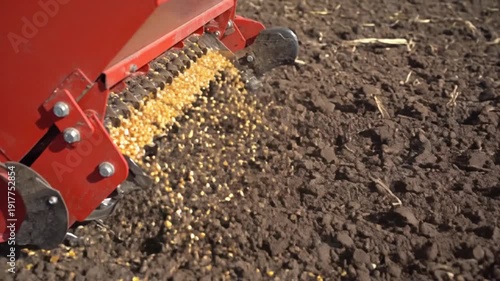 Farm equipment spreading seeds on fertile soil for planting