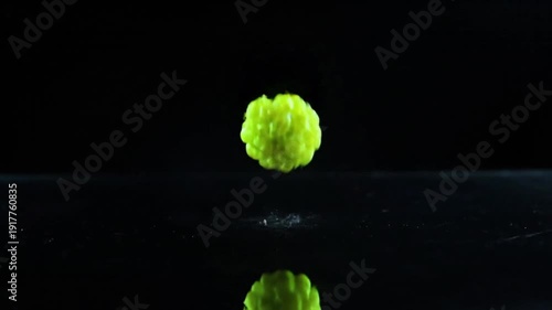 Fresh raspberries exploding with sparks on black background