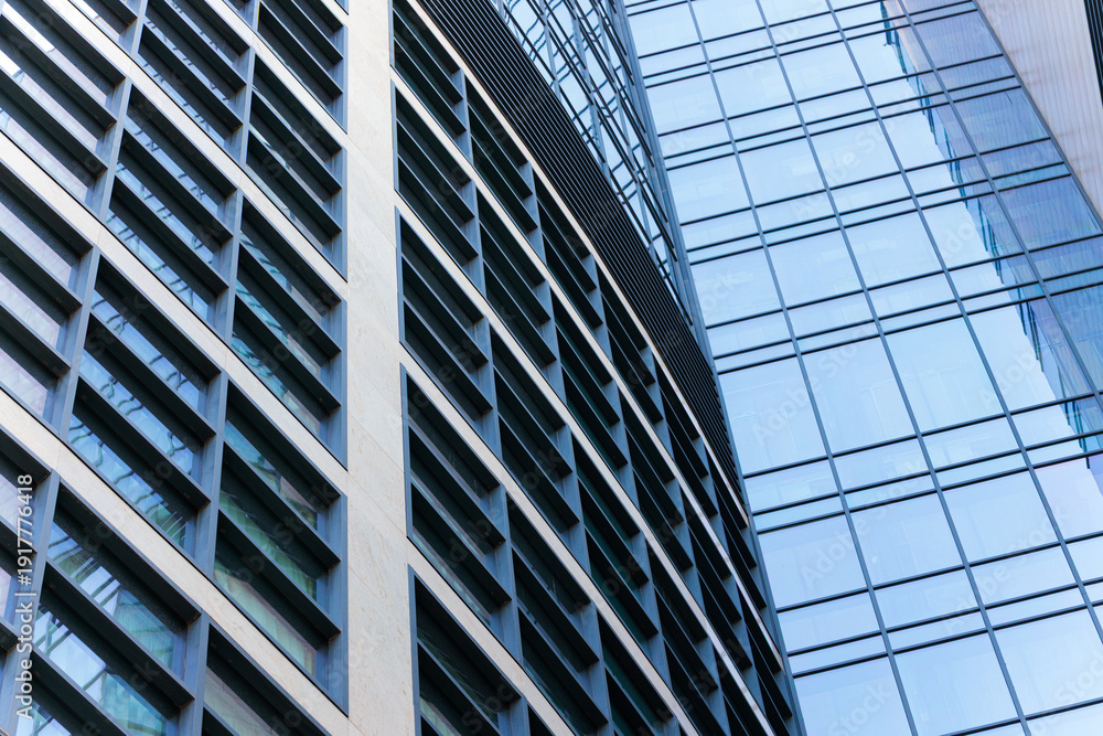 Obraz premium Modern glass skyscraper facade with geometric patterns and reflections close up perspective urban sky line view from below