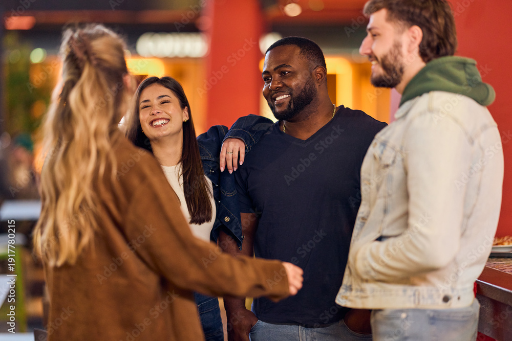 Obraz premium Friends Laughing And Talking Together In Casual Hangout At Night At A Modern Cafe