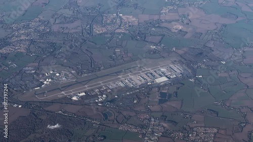 flying across Essex in United Kingdom with landscape around Stansted Airport  International Airport (IATA: STN, ICAO: EGSS) with runway, taxi ways and terminal buildings - 4k aerial video footage